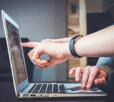 two persons using laptop